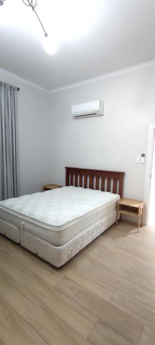 a white bedroom with a mattress on a wooden floor at Newtown Camp de Luxe in Wellington