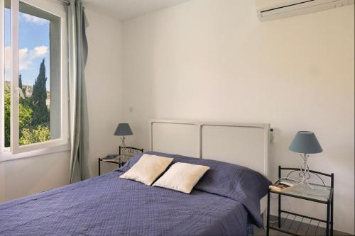 a bedroom with a purple bed and a window at Magnifique villa familiale avec piscine in Brando