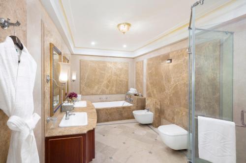 a bathroom with a tub and a toilet and a sink at Taj Fateh Prakash Palace Udaipur in Udaipur