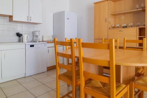 une cuisine avec une table en bois et un réfrigérateur dans l'établissement Maison de vacances - quartier calme - 6 personnes, à Les Sables-dʼOlonne