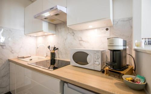 un comptoir de cuisine avec un micro-ondes et un évier dans l'établissement Cap jungle 2pers Centre-ville fibre, à Millau