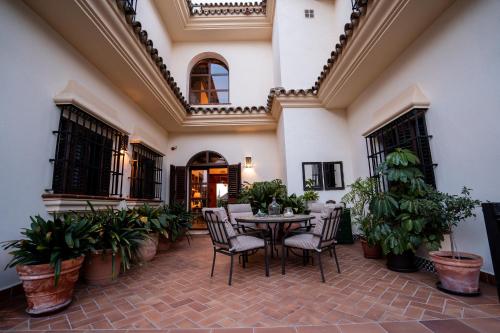 a dining room with a table and chairs and plants at Hotel Azalea Playa in Chiclana de la Frontera