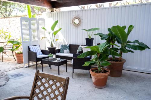 a patio with chairs and potted plants at Hotel Azalea Playa in Chiclana de la Frontera