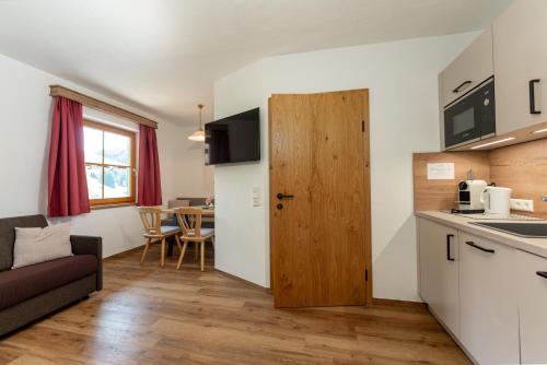a kitchen and living room with a couch and a table at Pension Bergbauernhof Irxner in Schladming
