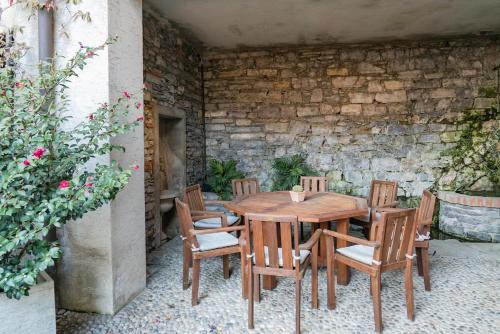 une table et des chaises en bois sur une terrasse dans l'établissement Civico 55 - Free parking & Garden, à Moltrasio