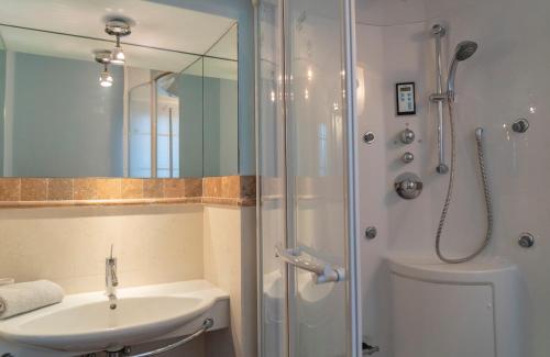 une salle de bain avec un lavabo et une douche avec un miroir dans l'établissement Civico 55 - Free parking & Garden, à Moltrasio