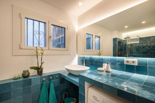 a blue and white bathroom with a sink and a mirror at Apartamento artístico Vilanova in Vilanova i la Geltrú