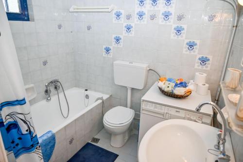 une salle de bain avec toilettes, baignoire et lavabo dans l'établissement Blue Waves, à Káto Ássos