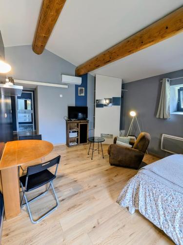 une chambre avec un lit, une table et un bureau dans l'établissement Studio du petit caillou en Drôme provençale , jacuzzi privatif en supplément, à Saint-Restitut