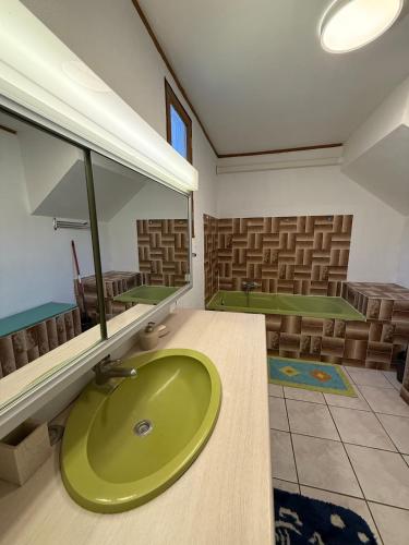 une salle de bain avec un lavabo vert et quelques chaises dans l'établissement Maison de campagne, à Châteaurenard