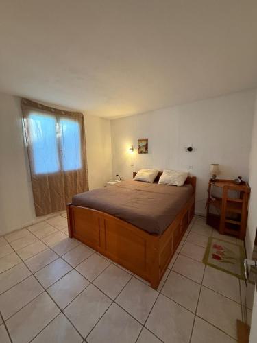 une chambre avec un grand lit et une fenêtre dans l'établissement Maison de campagne, à Châteaurenard