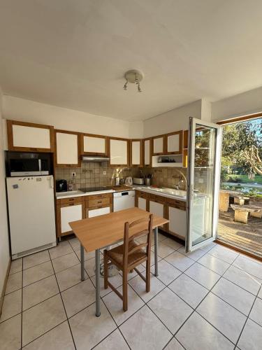 une cuisine avec une table en bois et un réfrigérateur dans l'établissement Maison de campagne, à Châteaurenard