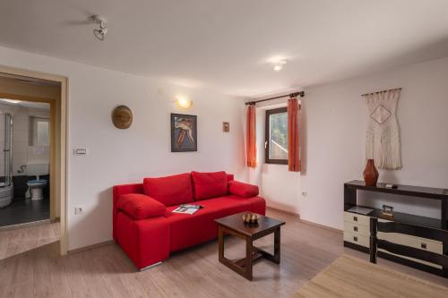 a living room with a red couch and a table at The Wave - Apt with Seaview and Garden - Happy Rentals in Kostrena