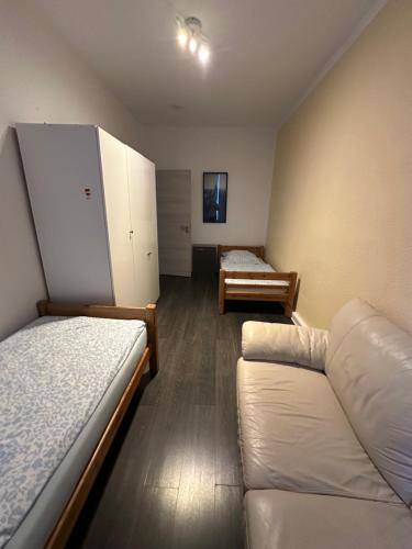 a room with two beds and a couch in it at Bezaubernde Ferien- und Monteurswohnung Nahe Leipziger Zentrum in Leipzig