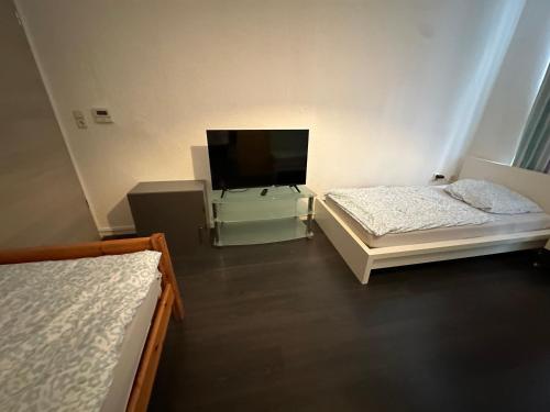 a room with two beds and a flat screen tv at Bezaubernde Ferien- und Monteurswohnung Nahe Leipziger Zentrum in Leipzig