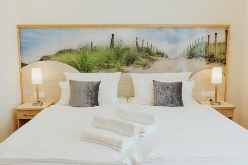ein Schlafzimmer mit 2 weißen Betten und einem Gemälde an der Wand in der Unterkunft Parkhotel IV Jahreszeiten Kühlungsborn in Kühlungsborn