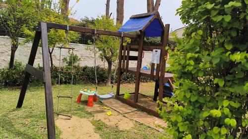 a playground with a swing in a yard at Calliope's Apartments - Stella del Mare in Siracusa