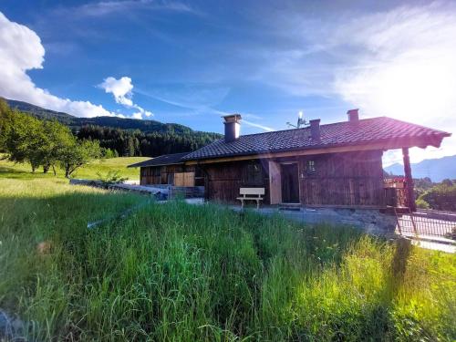 a wooden house with a grassy field in front of it at Charmantes Karwendel-Chalet in Wattens
