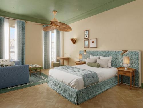 a bedroom with a bed and a ceiling fan at Hôtel Amista Marseille - ancien Hôtel Saint Louis - Vieux Port in Marseille
