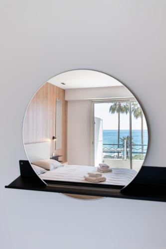 Cette chambre comprend un lit et un miroir. dans l'établissement Sublime T3 de standing - Croisette Cannes - Vue mer, à Cannes