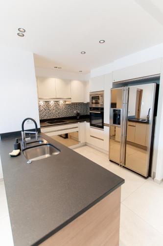 une cuisine avec des armoires blanches et des appareils en acier inoxydable dans l'établissement Sublime T3 de standing - Croisette Cannes - Vue mer, à Cannes