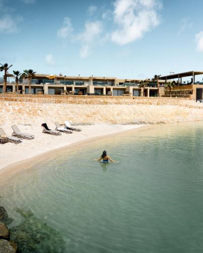 a person swimming in the water on a beach at Bavaro Beach Dakhla in Dakhla