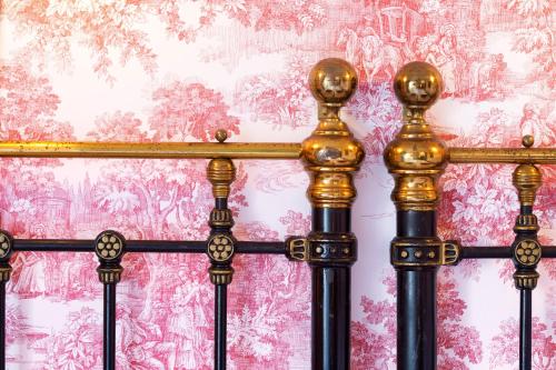 a fence with gold posts in front of a wall at Strandflickornas Havshotell Lysekil in Lysekil