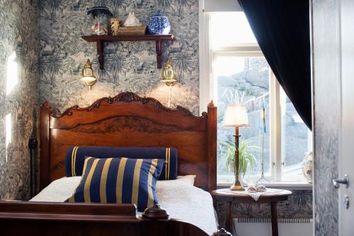 a bedroom with a wooden bed and a window at Strandflickornas Havshotell Lysekil in Lysekil