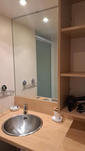 a bathroom with a sink and a large mirror at Chalet Domaine de la Forge in La Teste-de-Buch