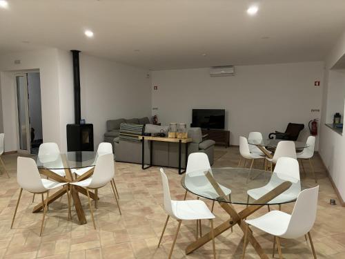 a living room with white chairs and a glass table at Villa Lobos Tavira in Tavira