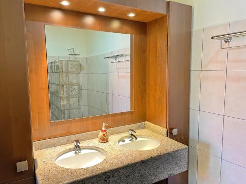 a bathroom with two sinks and a large mirror at Vrijstaande BB BEACH Villa Azure in Blue Bay