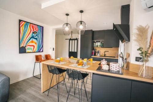 une cuisine avec un grand îlot et des tabourets de bar dans l'établissement Magnifique T3-terrasse-parking-Centre ville-AD, à Carcassonne