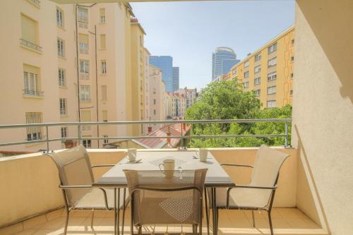 un balcon avec une table et des chaises sur un balcon dans l'établissement Charmant et Spacieux Part-Dieu Brotteaux, à Lyon