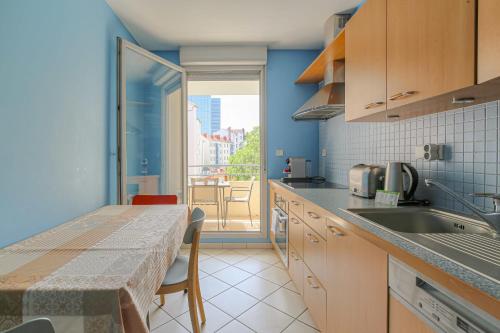 une cuisine avec une table et une vue sur un balcon dans l'établissement Charmant et Spacieux Part-Dieu Brotteaux, à Lyon
