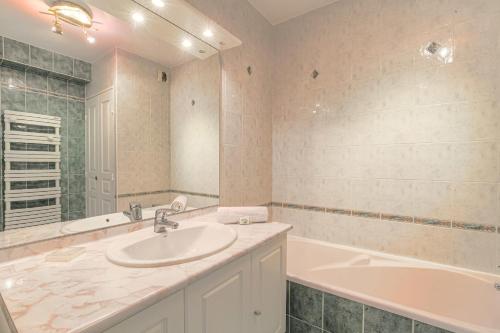 une salle de bain avec un lavabo et une baignoire dans l'établissement Charmant et Spacieux Part-Dieu Brotteaux, à Lyon