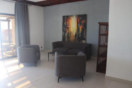 a living room with two chairs and a couch at Prince Anakao in Anakao