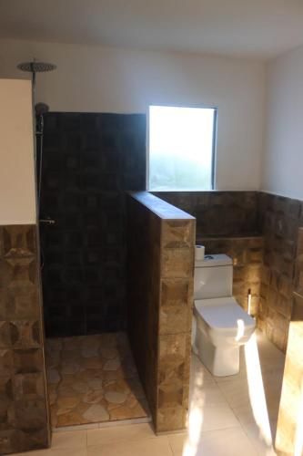 a bathroom with a toilet and a window at Prince Anakao in Anakao