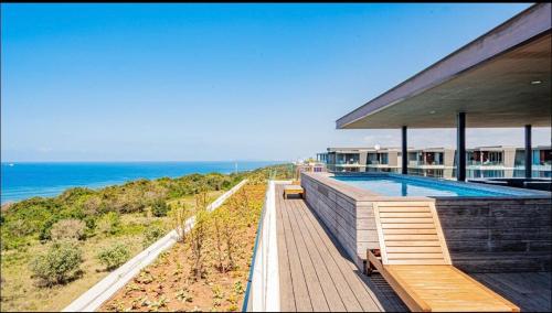 a house with a swimming pool next to the ocean at 2 Bedroom combo with pool at Ocean Dune, Sibaya in Umdloti
