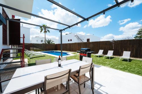 un patio avec une table, des chaises et un barbecue dans l'établissement Luxury villa in Sevilla - Pool, Terrace & GameRoom, à Montequinto