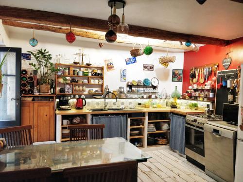 une cuisine avec des murs rouges et un grand comptoir dans l'établissement Chambre chez l'habitant, à Saint-André-de-Sangonis
