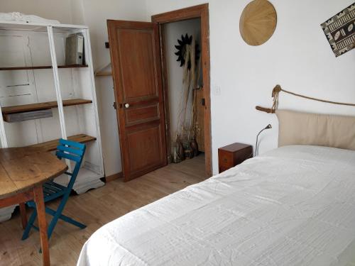 - une chambre avec un lit, une table et une porte dans l'établissement Chambre chez l'habitant, à Saint-André-de-Sangonis