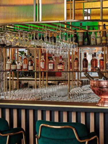 a bar with wine glasses on the wall at Mövenpick Grand Hotel Wroclaw in Wrocław