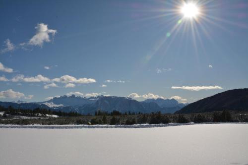 a view of a snow covered field with the sun at Schloss Gravetsch in Villandro