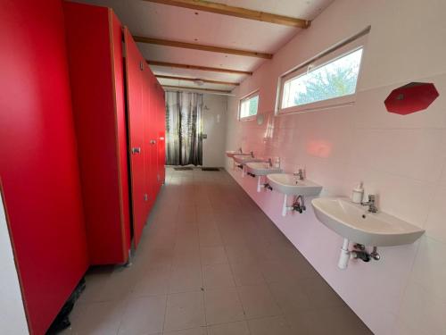 a bathroom with four sinks and red stalls at Rybářský sen in Olbramkostel