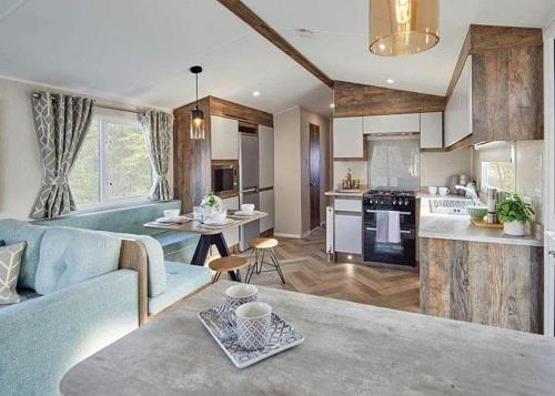 a living room and kitchen with a blue couch at Coastfields Holiday Village in Ingoldmells