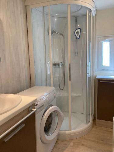 une salle de bain avec douche et machine à laver dans l'établissement Camping 4 étoiles - Piscine - ccafgbh, à Saint-Hilaire-de-Riez