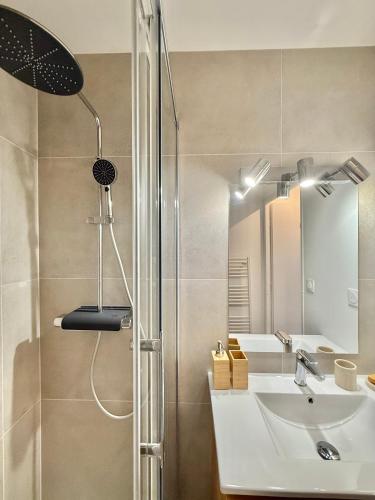 une salle de bain avec une douche avec un lavabo et un miroir dans l'établissement T2 Moderne - Quartier Cartoucherie - Proche Zénith & Purpan - Parking, à Toulouse
