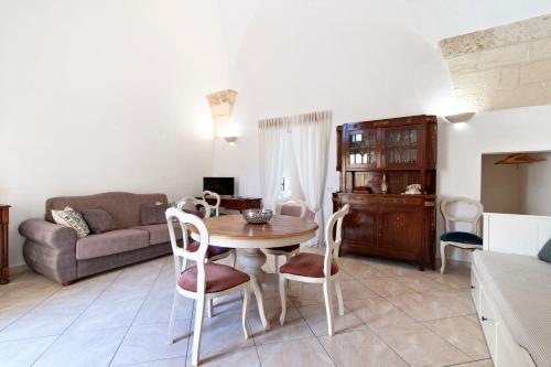 a living room with a table and chairs and a couch at Domus Aviae - No ZTL in Lecce