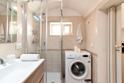 a bathroom with a washing machine and a sink at Domus Aviae - No ZTL in Lecce