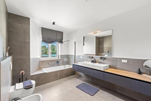 a bathroom with two sinks and a tub and a toilet at Villa Salteria 3, pool, private territory, pinery in Rovinj